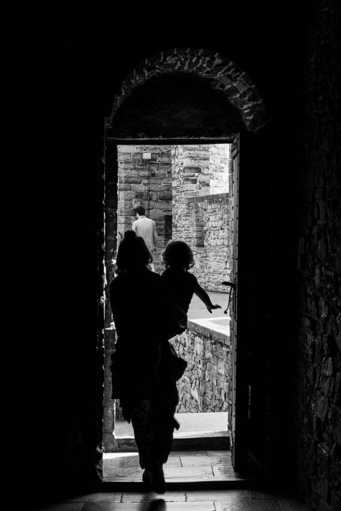 Donna con un bambino mentre esce da un ambiente buio