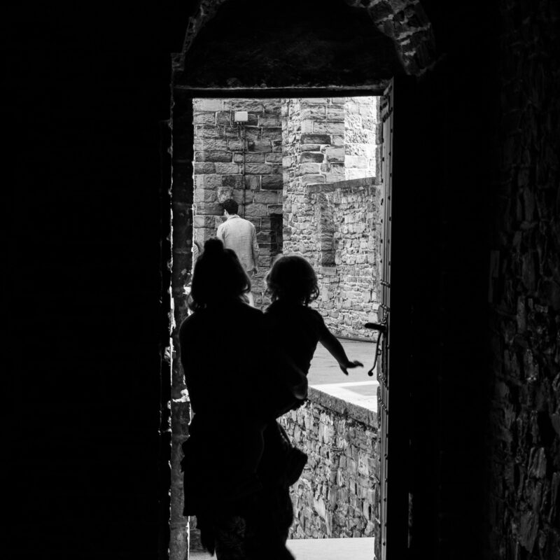 Donna con un bambino mentre esce da un ambiente buio